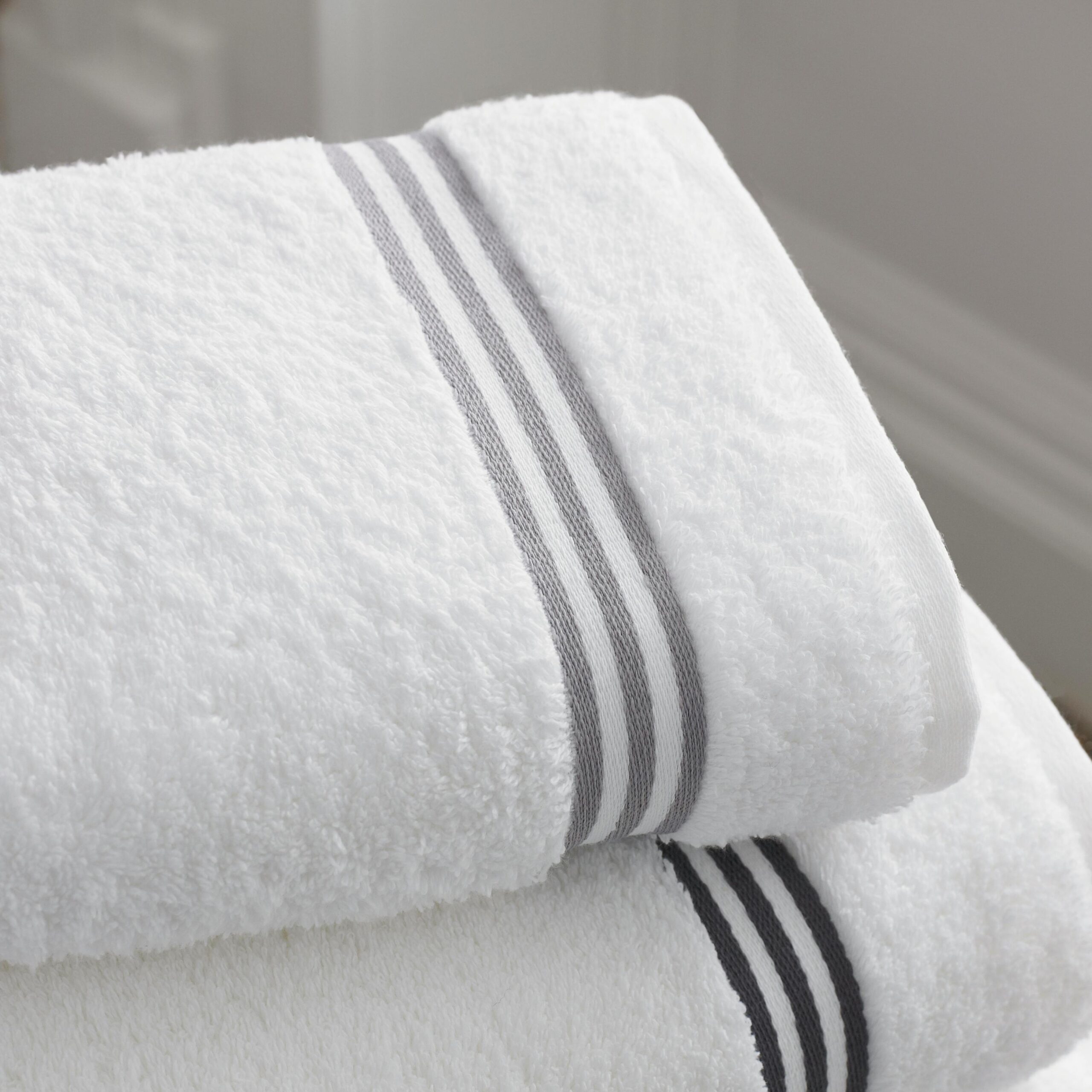"Woman wrapped in a soft white towel relaxing in a spa setting"
